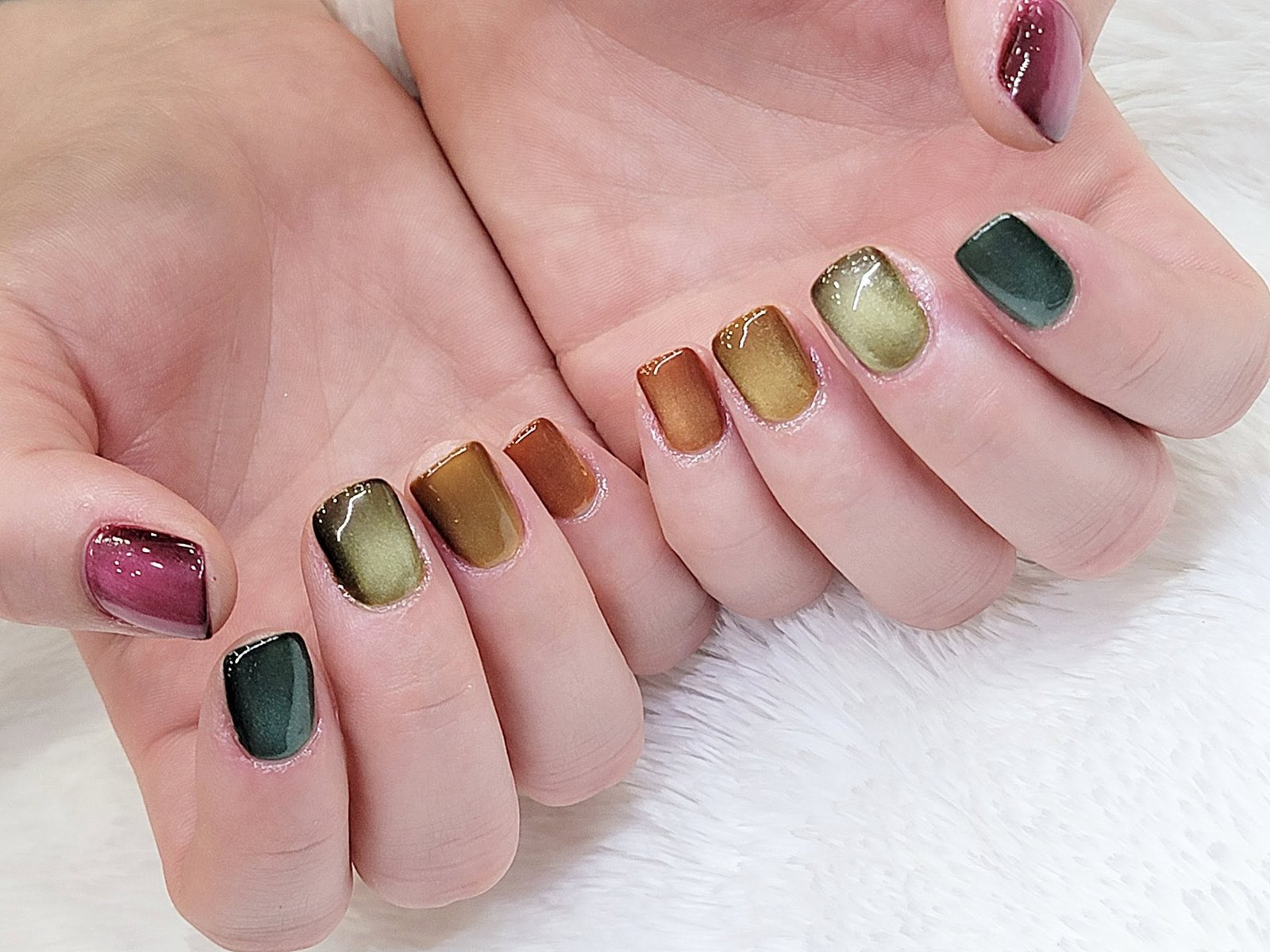 Warm autumn cat-eye manicure in shades of burgundy, rust, gold, and forest green