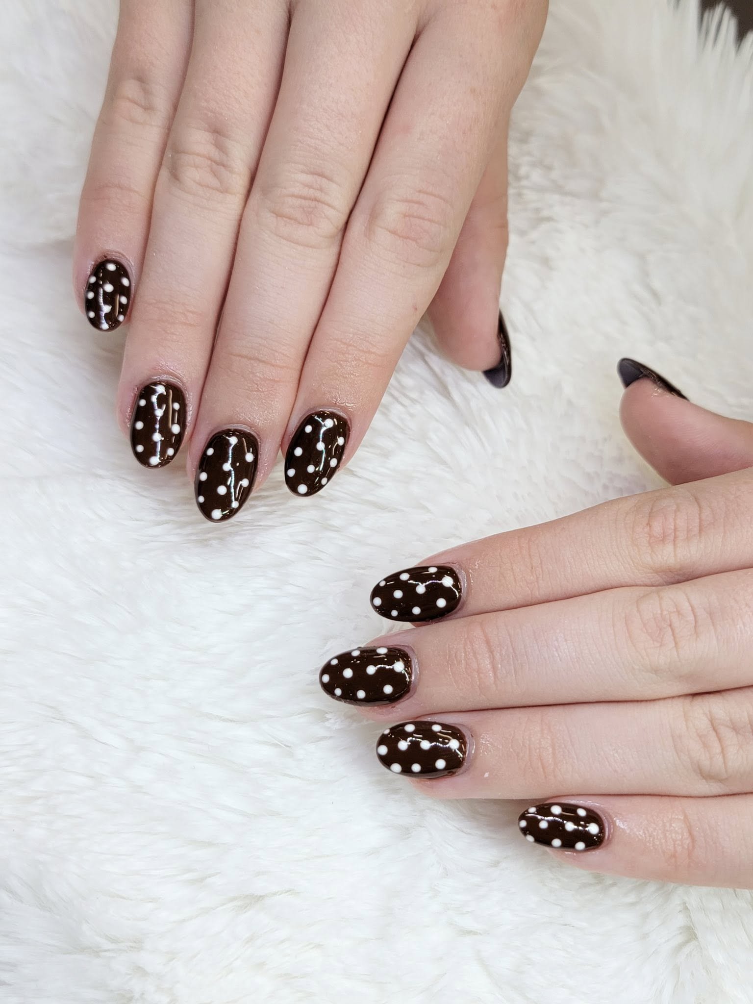Rich dark espresso brown almond nails with delicate hand-painted white polka dot constellation accents