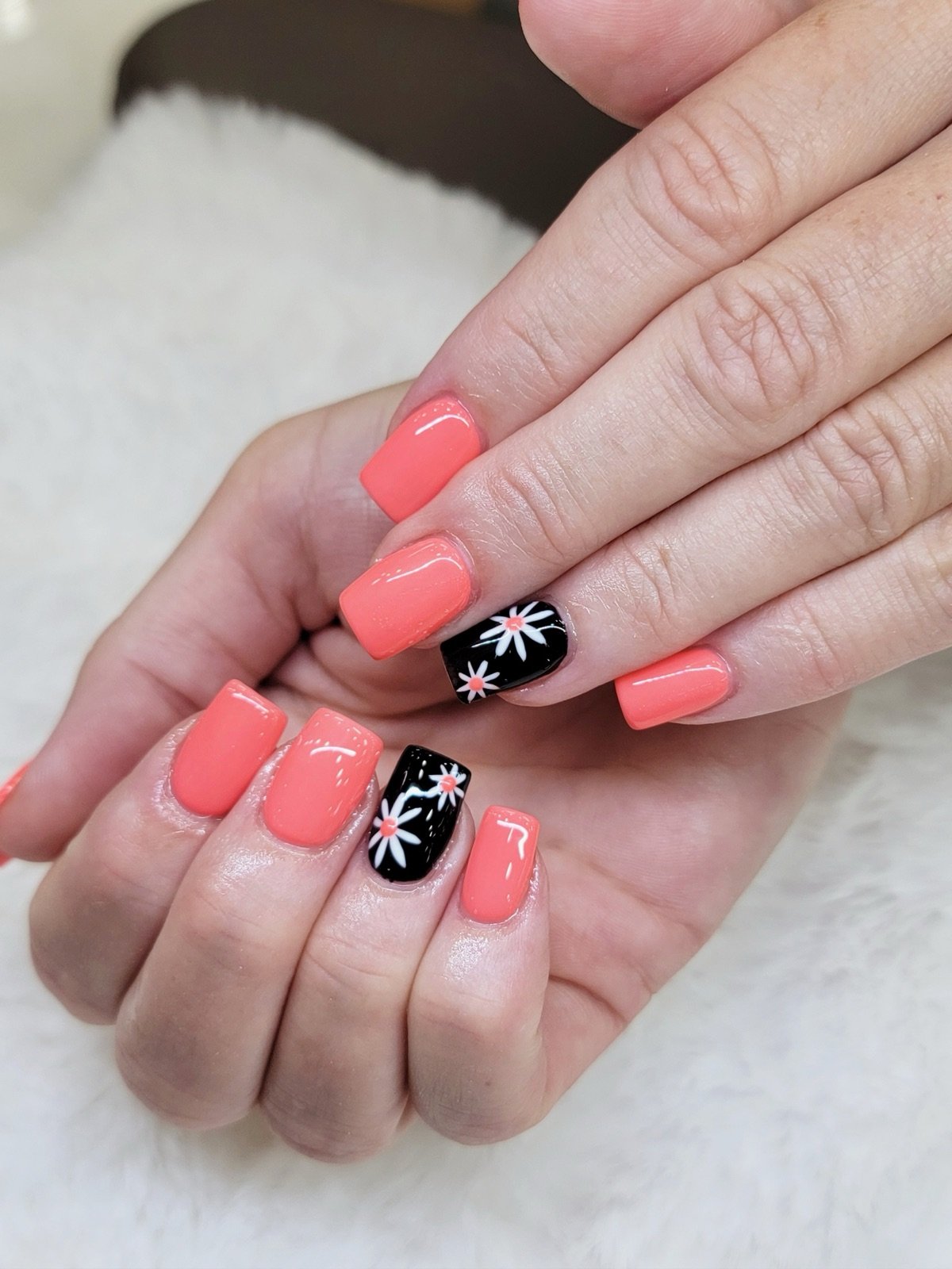 Coral pink nails with a black and white daisy accent nail